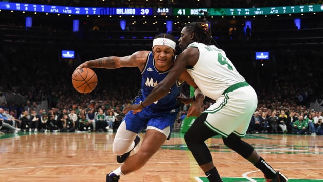 Dec 17, 2023; Boston, Massachusetts, USA; Orlando Magic forward Paolo Banchero (5) dribbles the ball while Boston Celtics guard Jrue Holiday (4) defends during the first half at TD Garden.